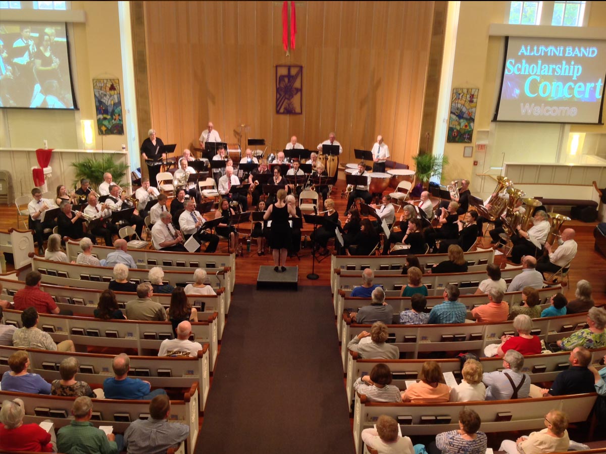 Alumni Band musicians performing on stage with instruments
